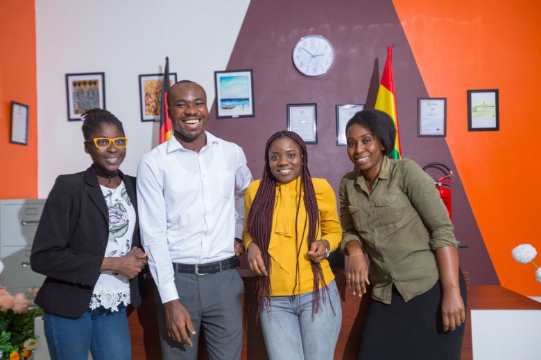 Four members of the HR team in Ghana standing in the office and laughing