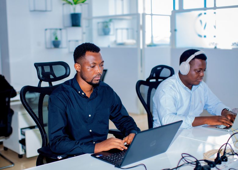 Two AmaliTech employees in the Rwandan office working on their computers