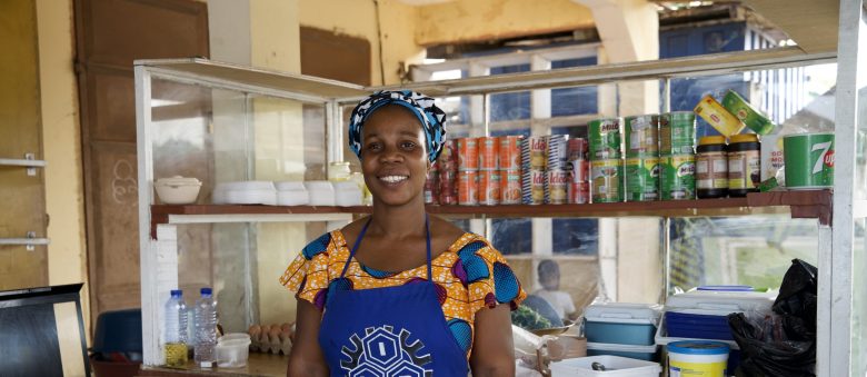A woman standing at her shop